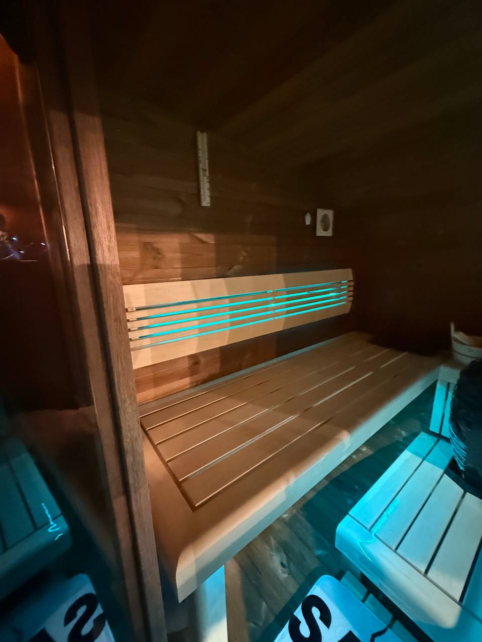 Palkkio Fasssauna Sitzbänke mit LED-Beleuchtung durch Glasfront fotografiert